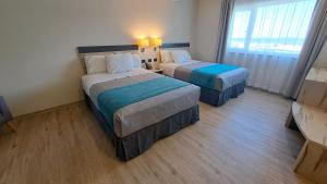 a hotel room with two beds and a window at Hotel Diego de Almagro Temuco Express in Temuco