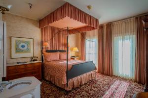 1 dormitorio con cama con dosel y lavamanos en Mendocino Hotel & Garden, en Mendocino