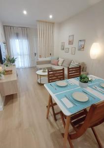 ein Wohnzimmer mit einem Tisch und einem Sofa in der Unterkunft Apartamento Sotavento Chipiona in Chipiona
