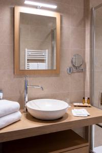 baño con lavabo blanco grande y espejo en Le Vieux Logis, en Trémolat
