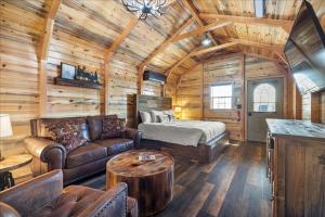 uma sala de estar com um sofá e uma cama num chalé de madeira em Big Horn Valley Ranch em Fort Smith