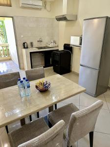 a kitchen with a table with chairs and a refrigerator at Hotel Fatima in Vila-de-Santiago-Maior