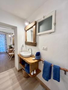 a bathroom with a sink and a tv on the wall at La Collina sul Mare in Campo nell'Elba