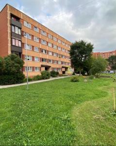 a large building with a grass field in front of it at Maleva apartaments in Kohtla-Järve