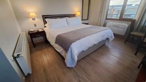 a bedroom with a large bed and a night stand at Hotel Diego de Almagro Valdivia in Valdivia