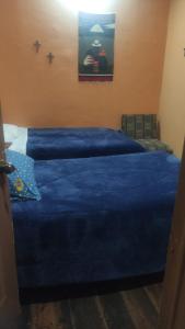 a bedroom with two beds with blue sheets at La Querencia in Cuenca