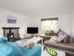 a living room with two couches and a fireplace at Ger Y Llan in Llangefni