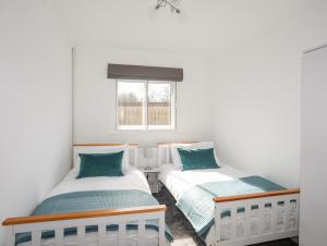 2 camas en una habitación con ventana en Ger Y Llan, en Llangefni