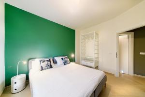 a bedroom with a large bed with a green wall at Casa Erica in Tirano