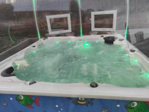 a jacuzzi tub with green lights in it at habitaciones en Chalet con piscina y jacuzzi en Madrid in Algete