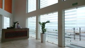 un homme debout dans une pièce avec de grandes fenêtres dans l'établissement Mi Apartamento en Cartagena, à Carthagène des Indes
