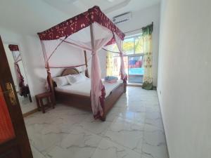 a bedroom with a bed with a canopy at BARIDI VILLA in Zanzibar City