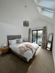 a bedroom with a large bed and a window at Modern Townhouse in the heart of Beaumaris in Beaumaris