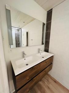 uma casa de banho com um lavatório branco e um espelho. em Ruim app. met grote garage em Ypres