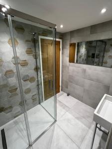 a glass shower in a bathroom with a sink at Modern Townhouse in the heart of Beaumaris in Beaumaris