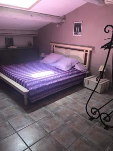 VelleronにあるHoliday home Gite De Marieのベッドルーム1室(紫のシーツと白い枕のベッド1台付)