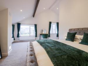 a bedroom with a large bed with a green blanket at The Bay Tree in Penrith