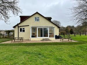 a house with two picnic tables in front of it at Court House Farmhouse in Bridport