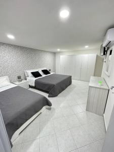 - une grande chambre avec 2 lits et une table dans l'établissement La casa di Pama, à Naples