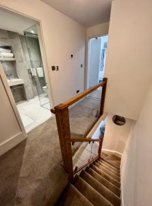 un escalier avec une porte en verre menant à une salle de bains. dans l'établissement Modern Townhouse in the heart of Beaumaris, à Beaumaris