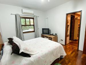 a bedroom with a bed with a teddy bear laying on it at Casa confortável com churrasqueira na Granja Viana in Carapicuíba