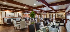 a restaurant with wooden ceilings and tables and chairs at Ayres Hotel Costa Mesa Newport Beach in Costa Mesa