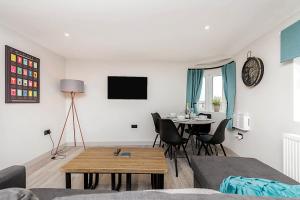 ein Wohnzimmer mit einem Tisch und einem Esszimmer in der Unterkunft The Burton Penthouse in Cheltenham
