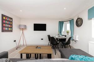 a living room with a table and a dining room at The Burton Penthouse in Cheltenham