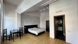 a bedroom with a bed and a desk and a table at Grand Hills in Yerevan