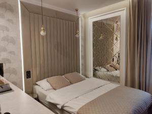 1 dormitorio con cama y espejo en StayCity - starówka Zielona Góra en Zielona Góra