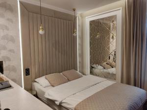 a bedroom with a bed and a mirror at StayCity - starówka Zielona Góra in Zielona Góra