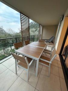 een houten tafel en stoelen op een balkon bij Prestige View 411 in Èze