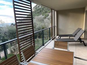 a balcony with a bench and a table and chairs at Prestige View 411 in Èze