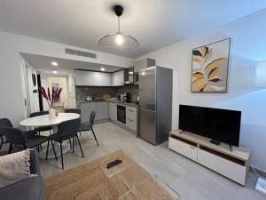a living room with a kitchen and a table with a television at Prestige View 411 in Èze