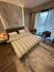 a bedroom with a large bed and a large window at Downtown pearl Amman in Amman