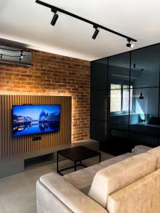 a living room with a tv on a brick wall at Anja & Ogo apartments with Pool _ in Petrovac na Moru