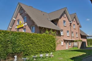 a building with a hedge and birds in front of it at Hotel Messeblick in Sarstedt