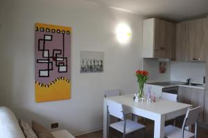 una cucina con tavolo bianco e tavolo e sedie bianchi di Beach House Riviera a Lignano Sabbiadoro