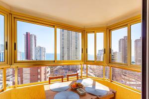 Pokój z oknami i stołem z owocami w obiekcie GERONA Levante beach apartments w mieście Benidorm