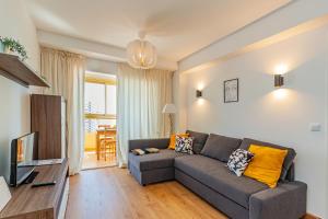 salon z kanapą i telewizorem w obiekcie GERONA Levante beach apartments w mieście Benidorm