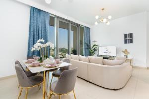 ein Wohnzimmer mit einem Sofa, einem Tisch und Stühlen in der Unterkunft Ultimate Stay / Directly Connected to Dubai Mall in Dubai
