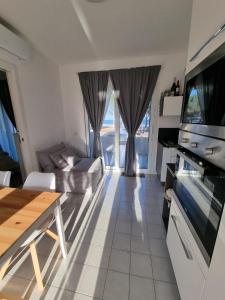 ein Wohnzimmer mit einem Sofa, einem TV und einem Tisch in der Unterkunft Villa Rosa in Bari Sardo