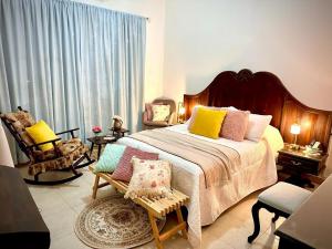 a bedroom with a large bed with colorful pillows at Freijoó Casa Vintage in Papantla de Olarte