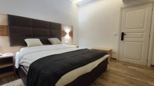 a bedroom with a large bed with a black headboard at Hotel 999 in Prato