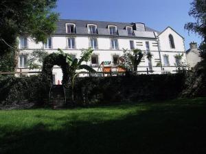 een groot wit gebouw met een boog in een tuin bij Appartement très lumineux avec belle vue dégagée in Rochefort-en-Terre
