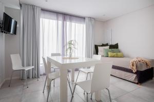 un comedor blanco con una mesa y sillas blancas en Be mas apartamentos boutique Valeria del Mar en Valeria del Mar