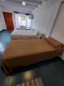 1 dormitorio con 2 camas, mesa y sillas en Vidorra Calafate en El Calafate