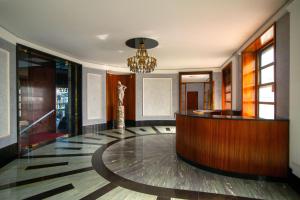 a lobby with a reception desk and a chandelier at Savoia Luxury Apartment in Milan