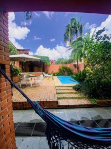 a hammock in front of a house with a patio at Refúgio com piscina e churrasqueira in Sao Paulo