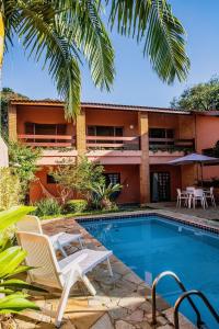 a resort with a pool and chairs and a building at Refúgio com piscina e churrasqueira in Sao Paulo